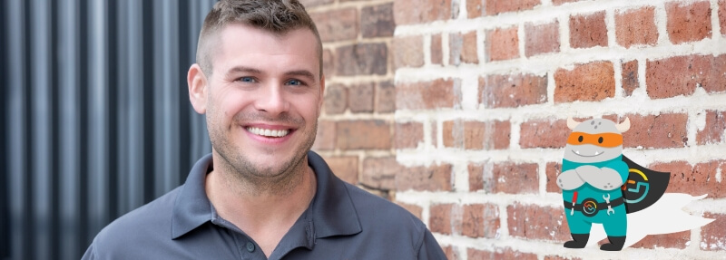 Man in front of a brick building smiling