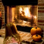 Little Girl By the Fire With Pumpkins