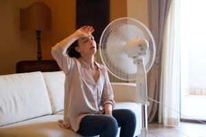 woman-sitting-in-front-of-floor-fan-looking-hot