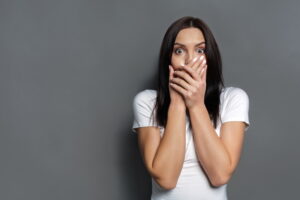 shocked-woman-covering-mouth-with-both-hands