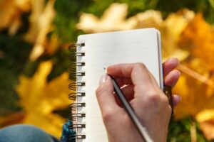 hand-creating-checklist-on-notepad
