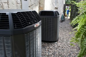 Dual outdoor heat pump HVAC units installed beside a home by professional heat pump contractors.